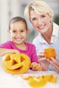 grandmother and granddaughter making halloween pumpkin